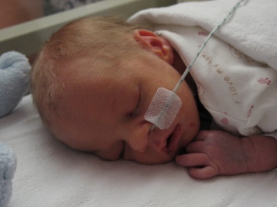 A baby, lying in a cot.